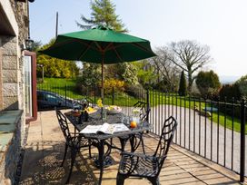 A patio with a table and chairs under an umbrella at High Beck in Kendal