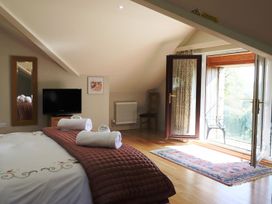 A bedroom with a bed and television at High Beck in Kendal