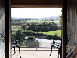 A balcony with chairs overlooking a landscape at High Beck in Kendal