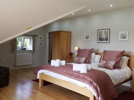 A bedroom with a bed and wardrobe at High Beck in Kendal