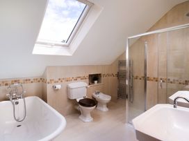 A bathroom with a bathtub, shower, and sink at High Beck, Kendal