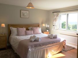 A bedroom with a bed and nightstand at High Beck in Kendal