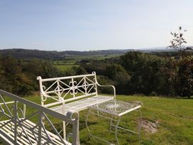 A bench and table in a garden with a view at High Beck in Kendal