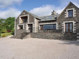 A stone house with a balcony and steps at High Beck in Kendal