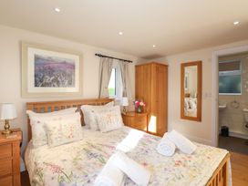 A bedroom with a bed and wooden furniture at High Beck Cottage in Kendal