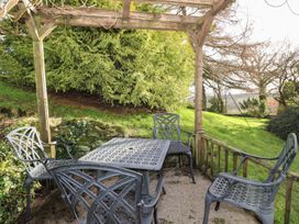 A patio area with a table and chairs at High Beck Cottage in Kendal