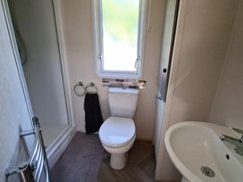 A bathroom with a toilet, sink and shower at Haven Golden Sands Abi Marina, Mablethorpe