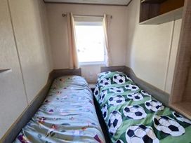 A bedroom with two beds and a window at Haven Golden Sands Abi Marina in Mablethorpe
