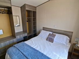 A bedroom with a bed and wardrobe at Haven Golden Sands Abi Marina Mablethorpe