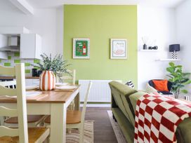 A living room with a dining area and a couch at Flat 1 Greenfields in Barmouth