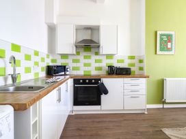 A kitchen with sink, stove, and microwave at Flat 1 Greenfields in Barmouth