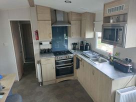 A kitchen with an oven microwave and sink at St Osyth Beach Clacton-on-Sea