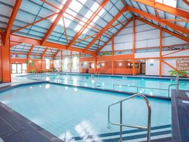 An indoor pool area with seating and a swim fun splash sign at St Osyth Beach in Clacton-on-Sea