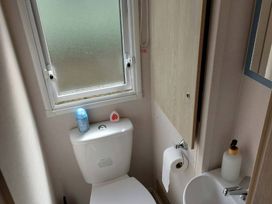 A bathroom with a toilet and sink at St Osyth Beach in St. Osyth