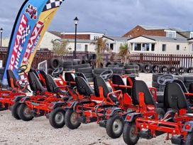 A row of go-karts parked next to tires at St Osyth Beach in St. Osyth