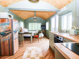 A kitchen with a table and chairs at Calendonia Hut West Mains near Haggerston