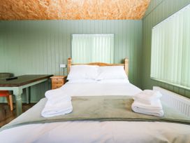 A bedroom with a bed and a table at Calendonia Hut, West Mains near Haggerston