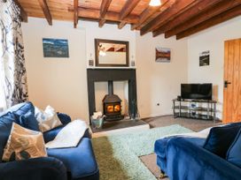 A living room with a fireplace and sofa at Acorn in Cleator