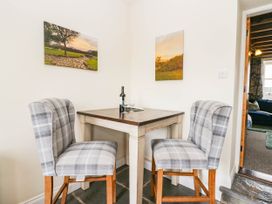 A dining area with a table and two chairs at Acorn in Cleator