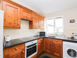 A kitchen with wooden cabinets and appliances at Acorn in Cleator