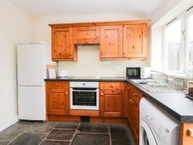 A kitchen with appliances and wooden cabinets at Acorn Cleator