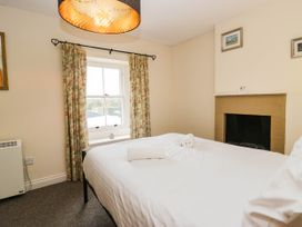 A bedroom with a bed and curtains at Acorn in Cleator