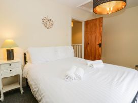 A bedroom with a bed and nightstand at Acorn in Cleator