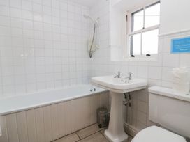 A bathroom with a bathtub, sink, and toilet at Acorn in Cleator