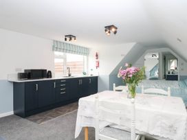 A kitchen with a dining table and chairs at Merlins Hideaway in Dawlish