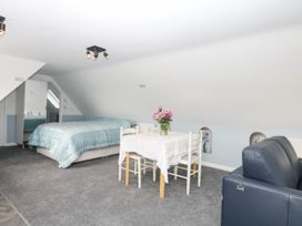 A bedroom with a bed and dining table at Merlins Hideaway in Dawlish