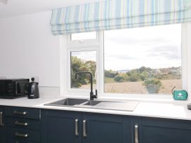 A kitchen with a sink, microwave, and kettle at Merlins Hideaway in Dawlish