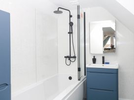 A bathroom with a bathtub and shower at Merlins Hideaway in Dawlish