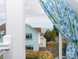 A view of houses and sea from a window at Merlins Hideaway in Dawlish