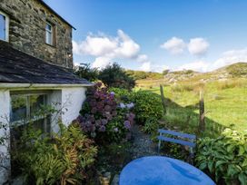 An outdoor area with a stone house and flowers at 2 High Moss House in Broughton-in-Furness