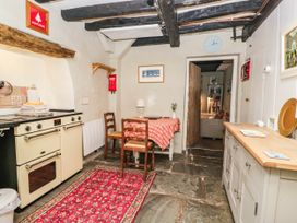A kitchen with an oven and table at 2 High Moss House Broughton-in-Furness