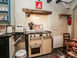 A kitchen with an oven, kettle, and utensils at 2 High Moss House in Broughton-in-Furness