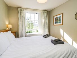 A bedroom with a bed and a lamp at 2 High Moss House in Broughton-in-Furness