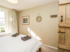 A bedroom with a bed and towels at 2 High Moss House in Broughton-in-Furness