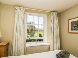 A bedroom with a window and curtains at 2 High Moss House in Broughton-in-Furness