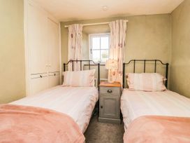 A bedroom with twin beds and a window at 2 High Moss House Broughton-in-Furness