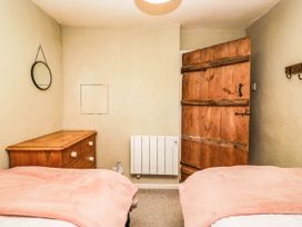 A bedroom with a bed and wooden furniture at 2 High Moss House in Broughton-in-Furness
