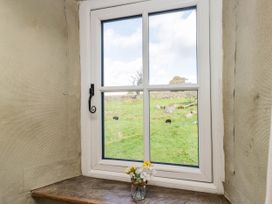 A window with flowers on a windowsill at 2 High Moss House in Broughton-in-Furness