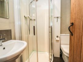 A bathroom with a shower, sink, and toilet at 2 High Moss House Broughton-in-Furness