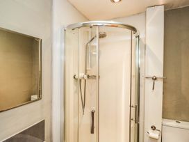 A shower enclosure and toilet in a bathroom at 2 High Moss House in Broughton-in-Furness