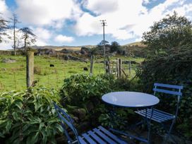 A garden with a table and chairs overlooking a field at 2 High Moss House Broughton-in-Furness