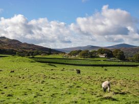 A rural landscape with sheep and a farmhouse at 2 High Moss House in Broughton-in-Furness