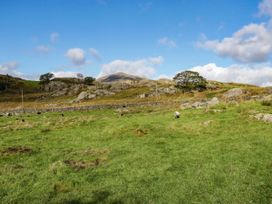 A field with sheep and rocks at 2 High Moss House in Broughton-in-Furness