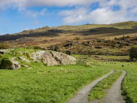 A landscape with a pathway and sheep grazing at 2 High Moss House in Broughton-in-Furness