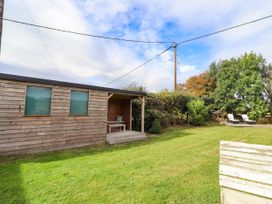 A wooden cabin with a table and chairs in an outdoor space at The Gables in Alnwick
