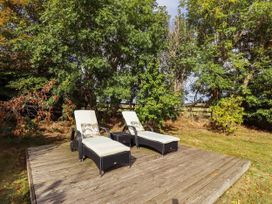 An outdoor area with sun loungers on a wooden deck at The Gables in Alnwick